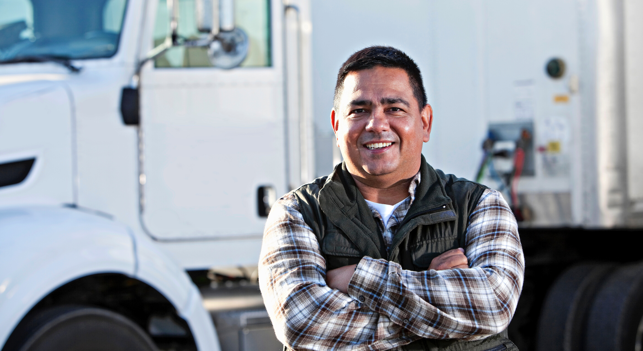 Truck driver smiling with arms folded