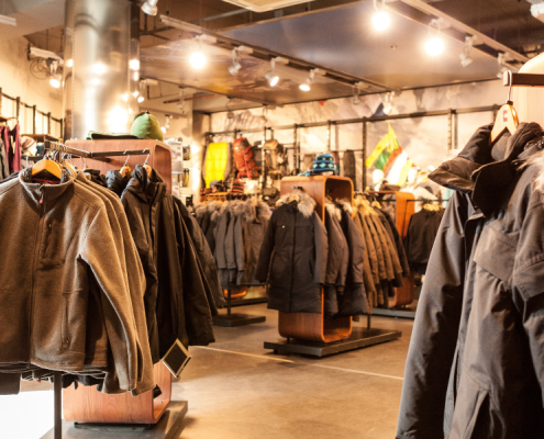 Coats hanging up at a dimly lit retail store