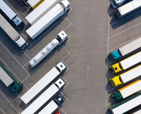 Semi trucks lined up on either side of a parking lot.