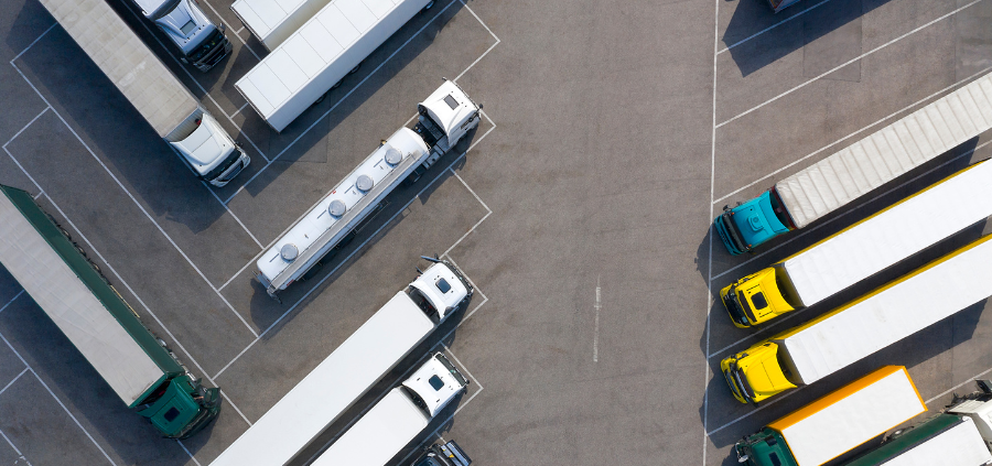 Semi trucks lined up on either side of a parking lot.